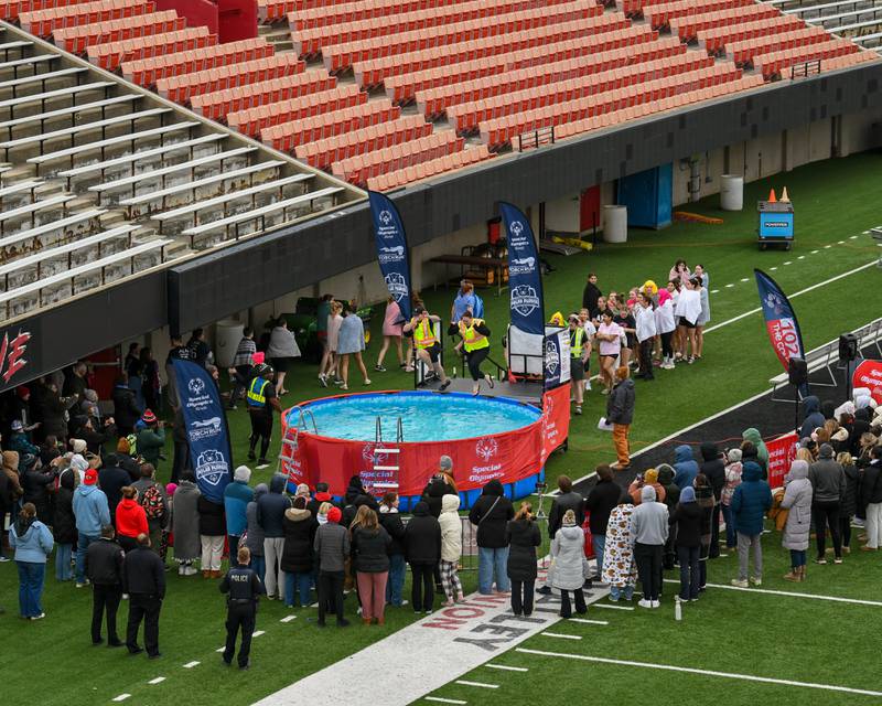 Members of the Sycamore police department jump in the pool during the Polar Plunge event on Saturday Feb. 21, 2026, held at Huskie Stadium in DeKalb.
