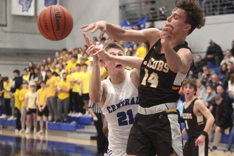 Burlington Central’s Drew Scharnowski (left) battles Jacobs’ Brett Schlicker in varsity boys basketball at Burlington Tuesday night.