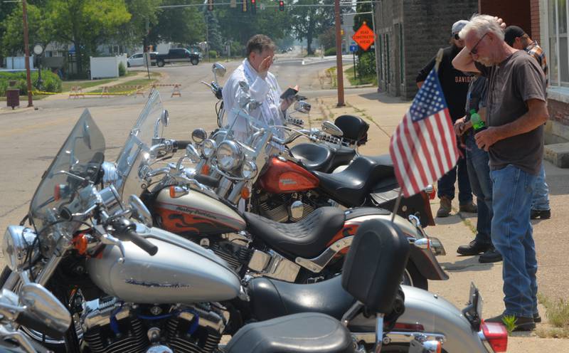Father Matthew Camaioni of the Immaculate Conception Church in Fulton blesses some of the 200 motorcycles that took part in a"Blessing of the Bikes", in downtown Fulton on Sunday, June 4. The event was started by Jules Meiners of Fulton several years ago and is now a fundraiser for the local food pantry. "It got so big we moved it to the main drag," she said. Clergymen blessed the bikes asking for a safe riding season. Here, bikers listen to the National Anthem before the blessings began.