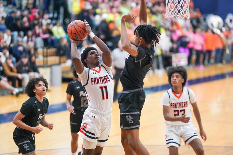 Oswego’s Rodney Richardson (11) shoots the ball in the post against Oswego East's Mason Lockett IV (2) during a basketball game at Oswego High School on Tuesday, Dec 12, 2023.