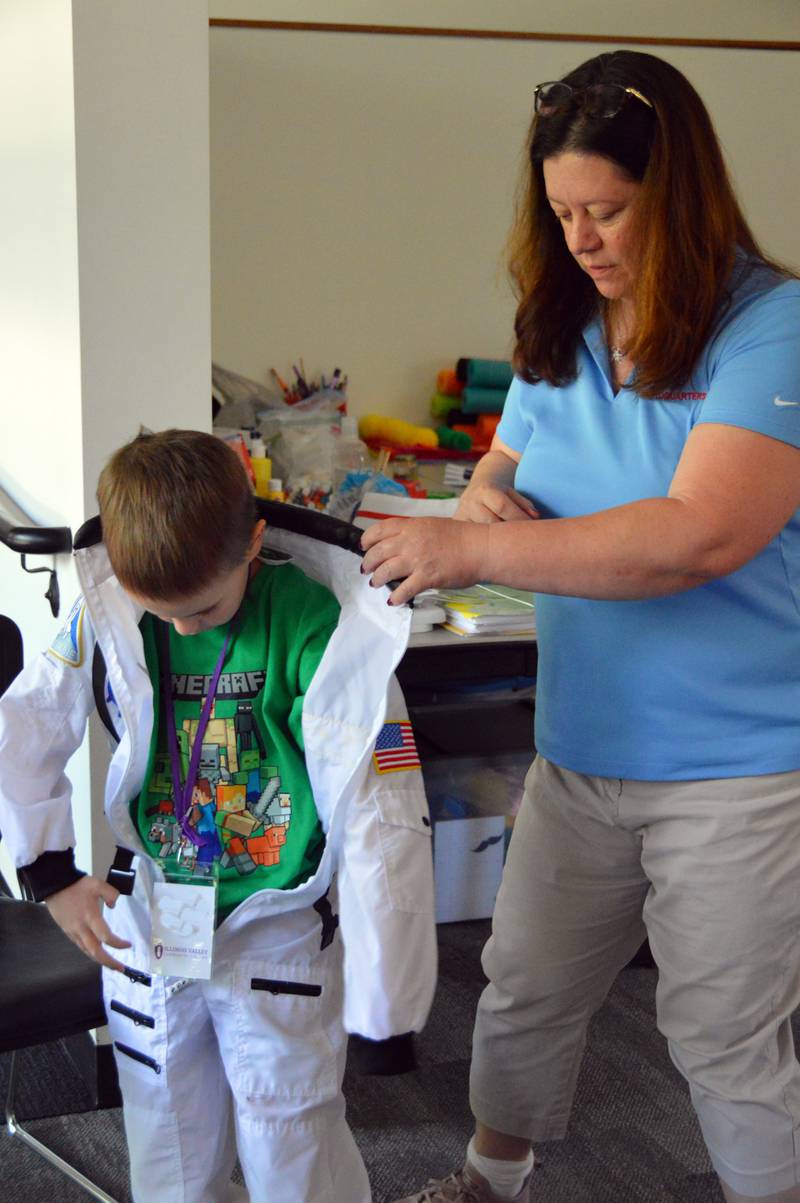 Barbara (Bendkowski) Hilton helps a young summer camper into a space suit during IVCC’s Space Camp. Working at NASA, Hilton is no stranger to space exploration, and she loves to share her experiences with people when she returns home to the Illinois Valley.
