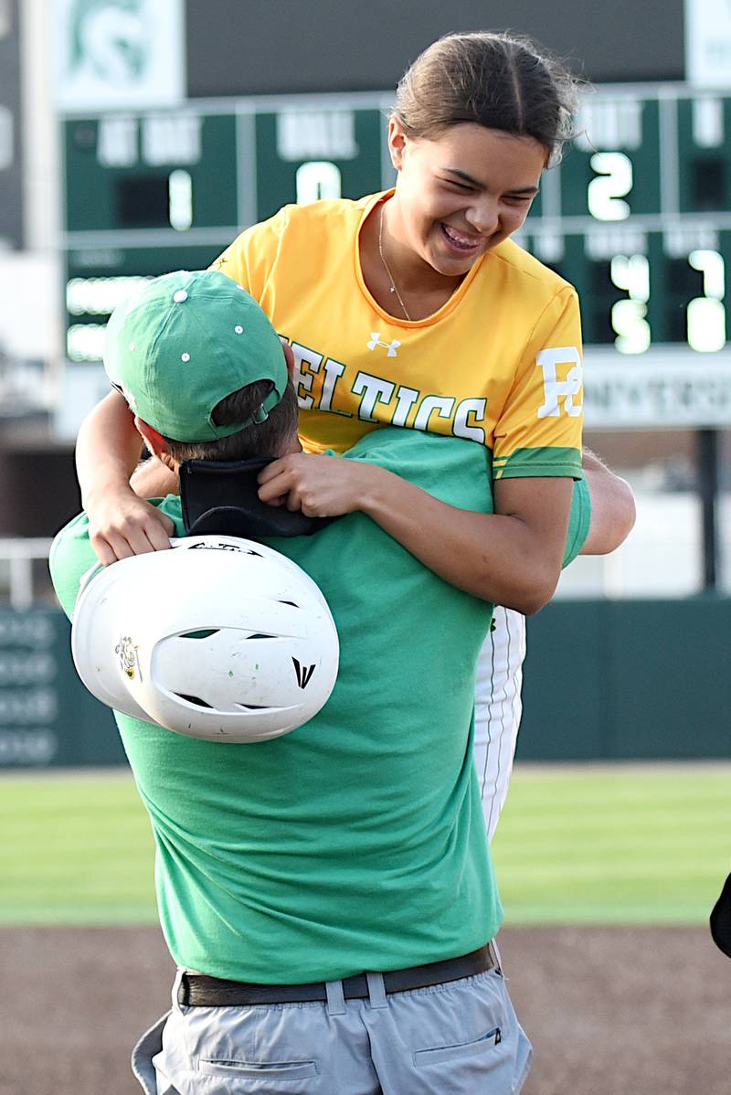 Providence's Bella Cortes is hoisted into the air by head coach Jim Holba after her walk-off single in the ninth inning of the Celtics' 5-4 win in nine innings over Pontiac in the Class 3A Illinois Wesleyan Supersectional Monday, June 9, 2025.