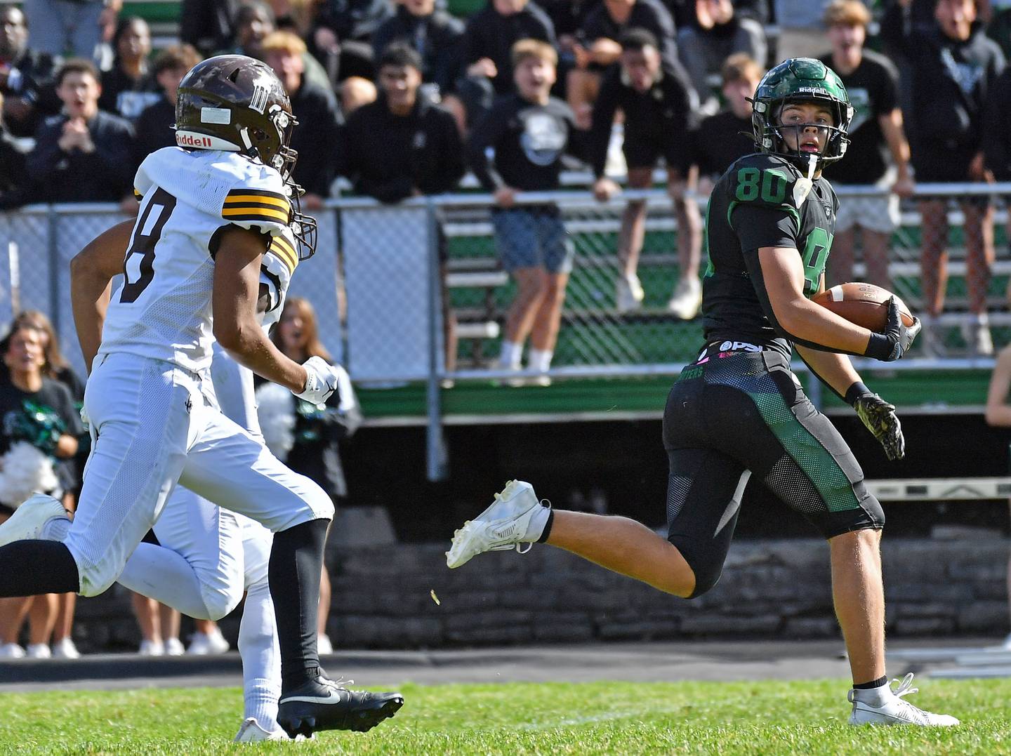 Glenbard West’s Brady Johnson (right) looks back at Joliet Catholic defenders as he makes a touchdown run after a catch during a game on September 6, 2025 at Glenbard West High School in Glen Ellyn.