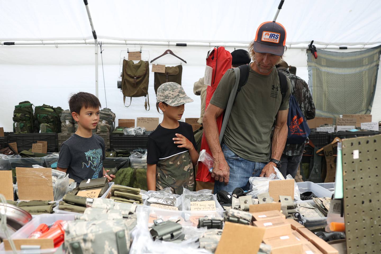 Blair Konczal, right, and his two sons Logan, 10-years old, and Luke, 8-years old, look over military items at one of the vendor tents at Lockport Military History Days at Dellwood Park on Saturday, Sept. 9, 2023 in Lockport.
