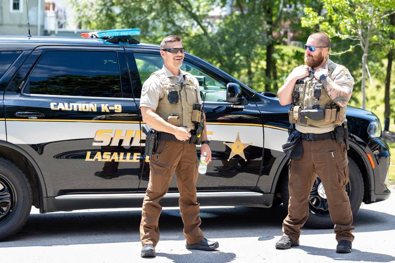 (left to right) Bryan Denault and Cody Greenway stand next to sheriff vehicle at the Touch a Truck event on Saturday, June 28, 2025 at Centennial Park in Peru.