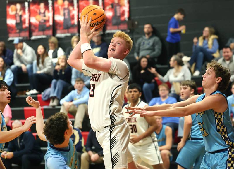 Indian Creek's Isaac Willis gets up a shot in the lane over Marquette’s Lucas Craig Monday, Dec. 9, 2025, during their game at Indian Creek High School in Shabbona.