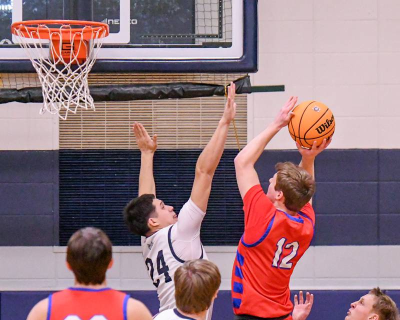 Glenbard South's Mitchell Erickson (12) takes a shot during the game while being defended by West Chicago's Oliver Muñoz (24) during the game on Friday Jan. 3, 2025, held at West Chicago High School.