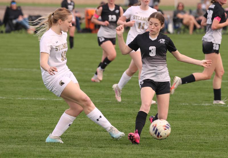 Sycamore's Caedyn Waxman kicks the ball by Kaneland's Arden Stoddard Monday, April 13, 2026, during their game at Kaneland High School.