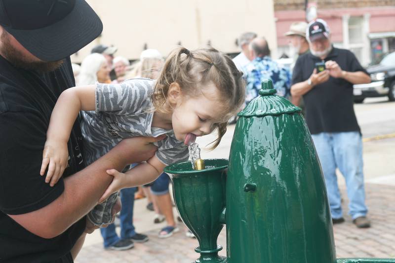 Arya Runyon Oregon, takes a sip of water from Iron Mike after the historic, free-flowing water fountain was turned back on in 2021 following 2-years of restoration work. The iconic fountain hasn't been turned on this year due to more repairs.