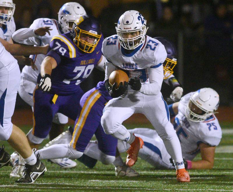 Lakes' Amir Al Hindi (23) gains some ground past Wauconda's Tyler Schmidt (79) during Friday’s football game in Wauconda.