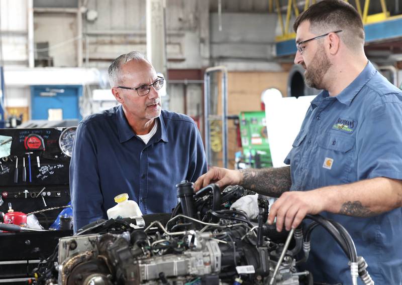 Jon Bockman, (left) owner of Bockman’s Auto, Truck & Tire, talks to lead technician Adam Zonka Friday, Aug. 2, 2024, about a repair they are working on at the DeKalb location on Industrial Drive.