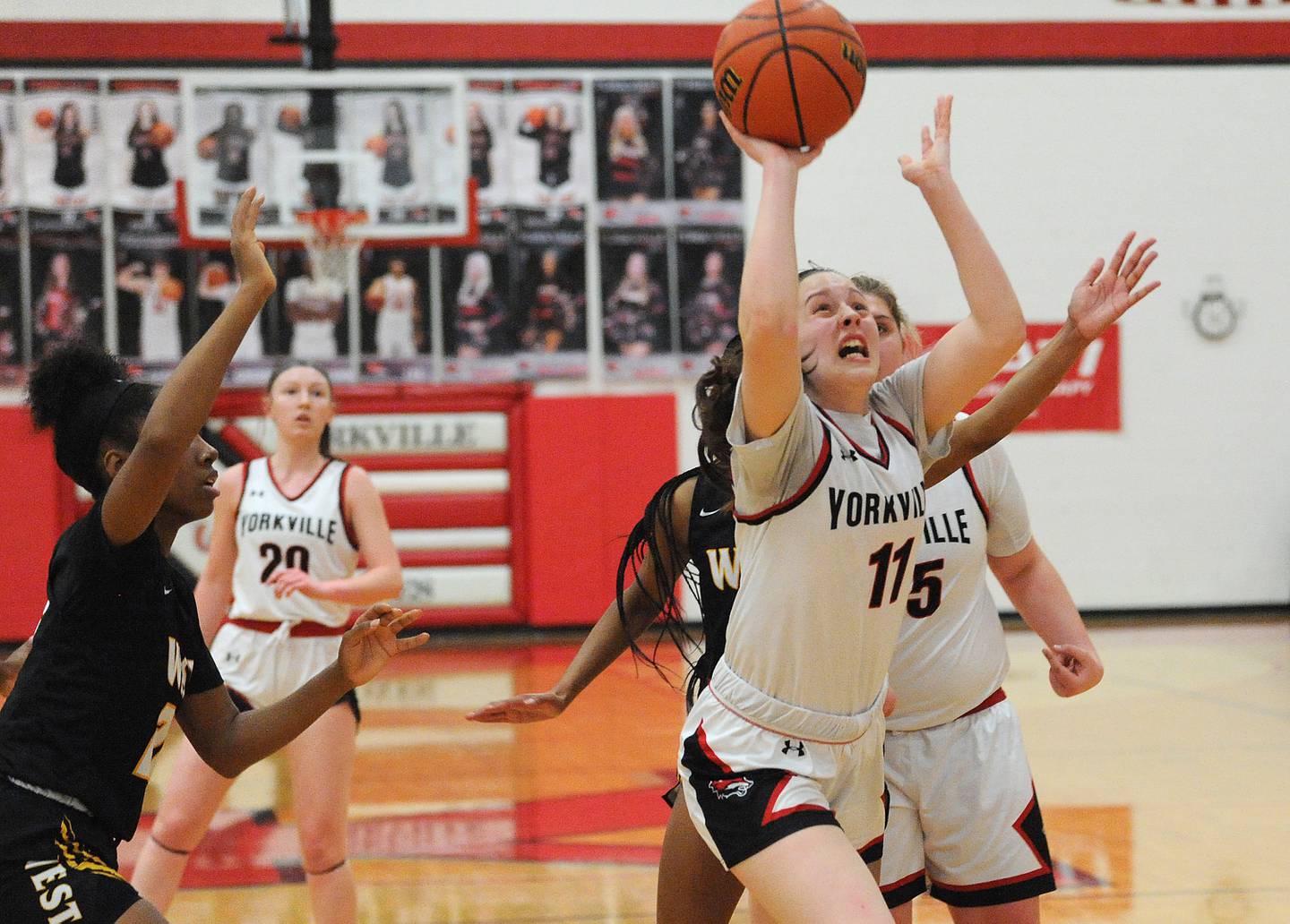 Yorkville's Brooke Spychalski (11) gets through the Joliet West defense and scores as time runs out in the 2nd quarter during a girls' basketball game at Yorkville on Thursday, Jan. 19, 2023.