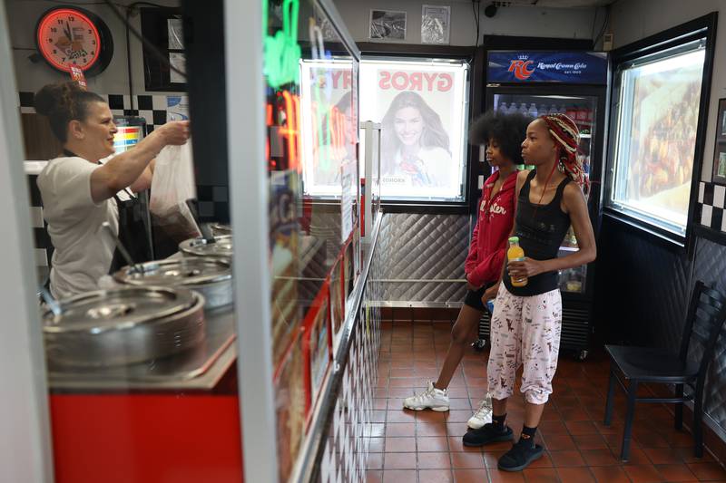 Sub Dock employee Donetta Jones, left, hands an order to Luvenia Michell and her mother, Sondra Johnson.