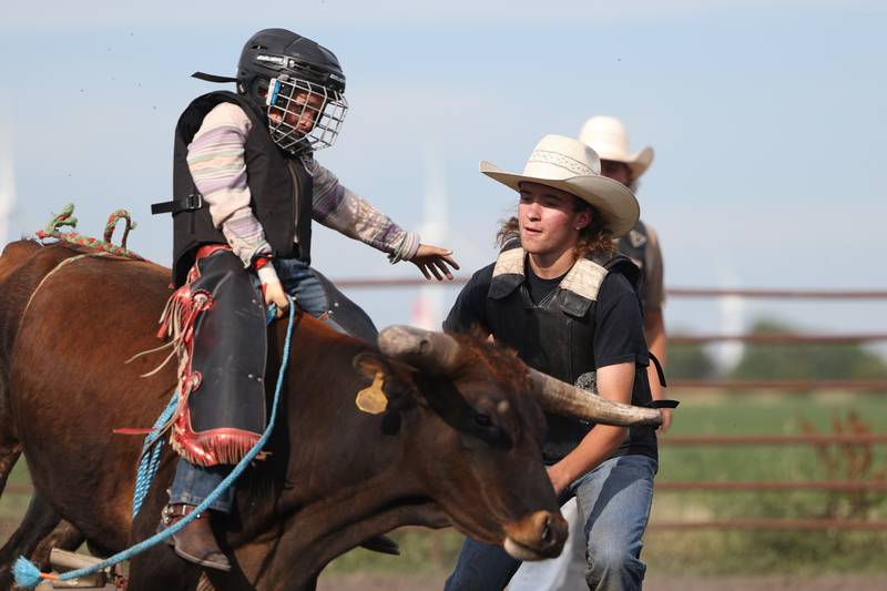 Dominic Dubberstine-Ellerbrock, right, spots Wyatt Plese during his bull ride. Dominic will be competing in the 2022 National High School Finals Rodeo Bull Riding event on July 17th through the 23rd in Wyoming. Thursday, June 30, 2022 in Grand Ridge.
