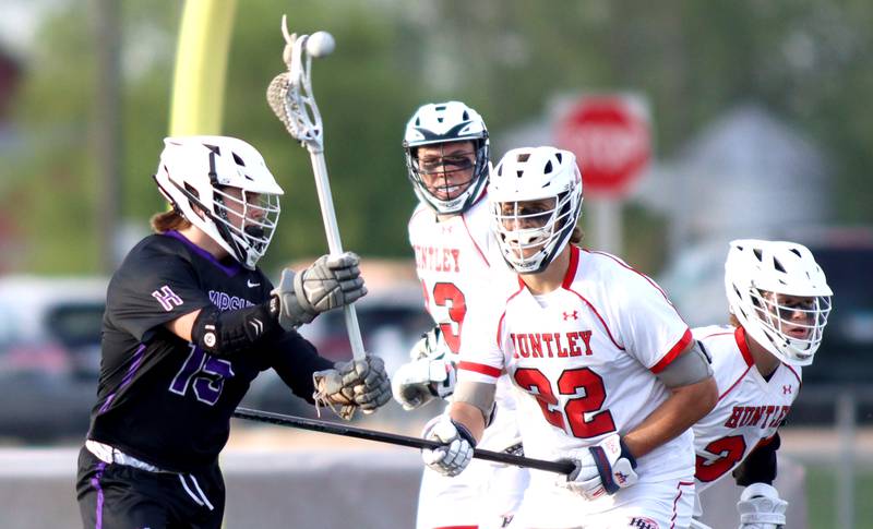 Huntley’s Tyler Readinger, right, plays defense as Hampshire’s  Cambell Smith, left, passes the ball in varsity lacrosse at Huntley Thursday night.