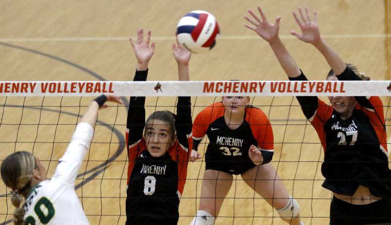 Crystal Lake South's Morgan Johnson (left)  hits the ball into the defense of McHenry's Brooke Rockweiler, (8) Bella Mclain, (32) and Lily Ahrens (27) during a Fox Valley Conference volleyball match on Thursday, Aug. 28, 2025, at the Freshman Campus of McHenry High School in McHenry.