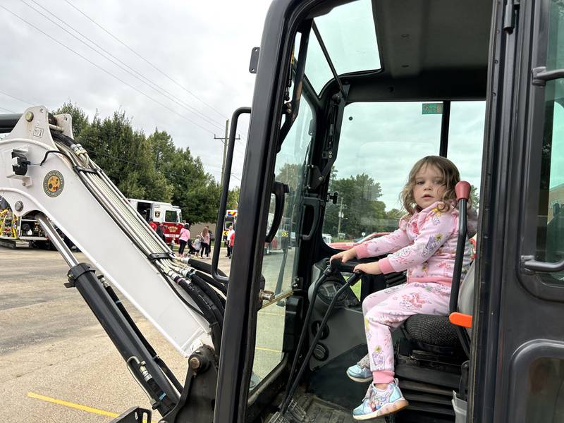 Eliza Swedberg, 3, of Lost Lake, sits in the driver's seat of an Oregon Public Works backhoe at the Oregon Police Department's National Night Out on Tuesday, Aug. 6, 2024. The event was co-hosted by the Oregon Park District at River's Edge Experience.