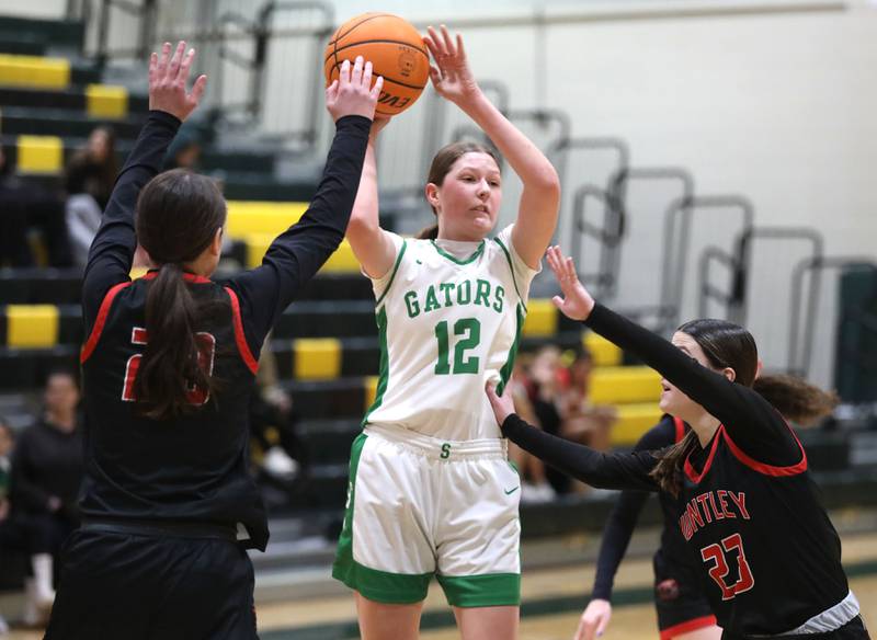 Crystal Lake South's Gaby Dzik pass out of a double team of Huntley's Alyssa Borzych (left)  and Aubrina Adamik (right) during a Fox Valley Conference girls basketball game on Friday, Jan. 30, 2026, at Crystal Lake South High School.