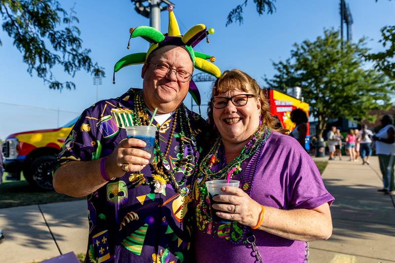 Joliet residents Kalvin and Diane Godsey take a photo in their Mardi Gras finest during New Orleans North Festival at Joliet Slammers Stadium on Aug. 15, 2025.