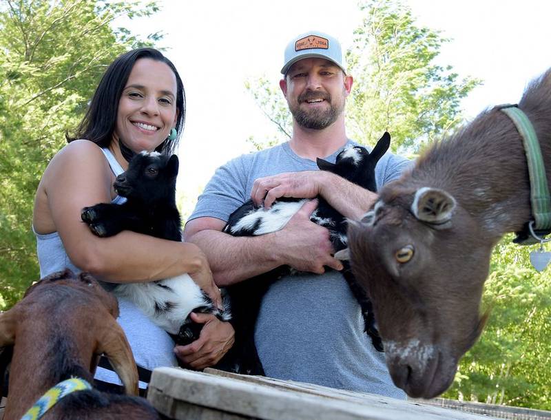 Danielle and Brad Kerr hold their new baby goats Dre and Snoop at their Reverse the Kerrs Farm in Elgin.