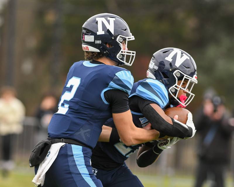 Nazareth Academy's Jackson Failla (2) hands the ball off to teammate Charles Calhoun (27) while taking on Fenwick high school during the 6A semifinals game on Saturday Nov. 22, 2025, held at Nazareth Academy High School in La Grange Park.