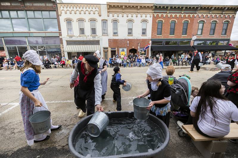Tanks of water are set up along the parade route Saturday, May 3, 2025, in Fulton so that the washers can reload their buckets for the annual tradition.