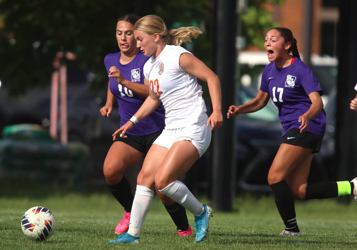 Hampshire’s  Hope Lorbiecki, left, and Helen Negron, right, pursue Crystal Lake Central’s Olivia Anderson in varsity soccer at Hampshire Tuesday evening.