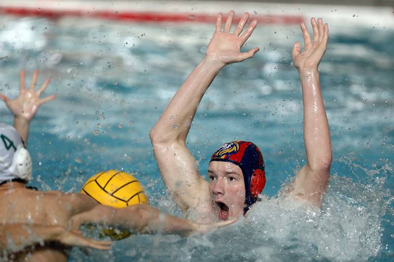 Lyons' Charlie Vlk (1) blocks a shot against York during the IHSA State Water Polo consolation match Saturday May 20, 2023 at Stevenson High School in Lincolnshire.