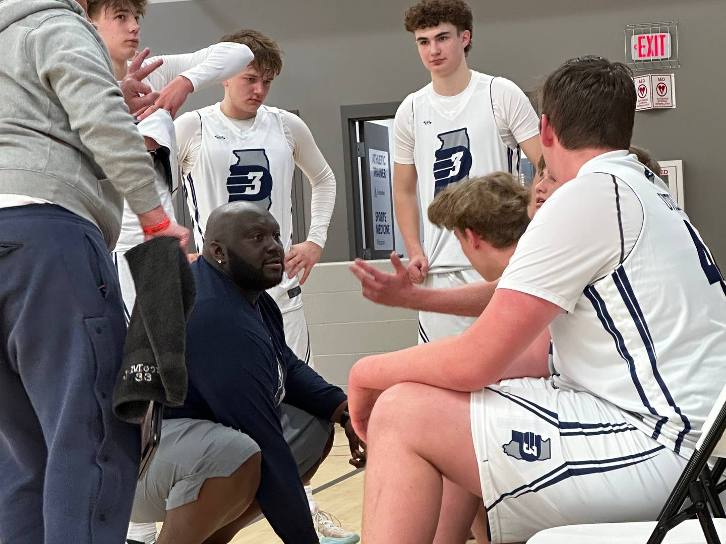 Jay Moore, the founder of TRUTH Basketball Academy and a DeKalb High School coach, huddles up with his team.