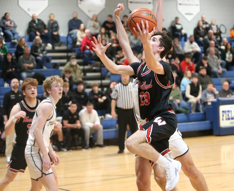 Woodland's Nick Plesko drives to the hoop around Fieldcrest's Brady Ruestman to score a basket on Tuesday, Dec. 19, 2023 at Fieldcrest High School.