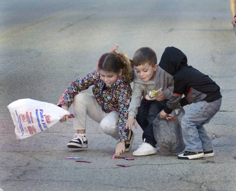 Children look for candy treats tossed their way Saturday during the Marseilles Lighted St Patrick’s Day Parade.