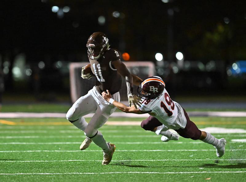 Joliet Catholic's Justin Bonsu (11) tries to avoid getting tackled by Brother Rice's Jake Dugger (19) on Friday, Oct. 07, 2022, at Joliet Memorial Stadium. (Dean Reid for Shaw Media)