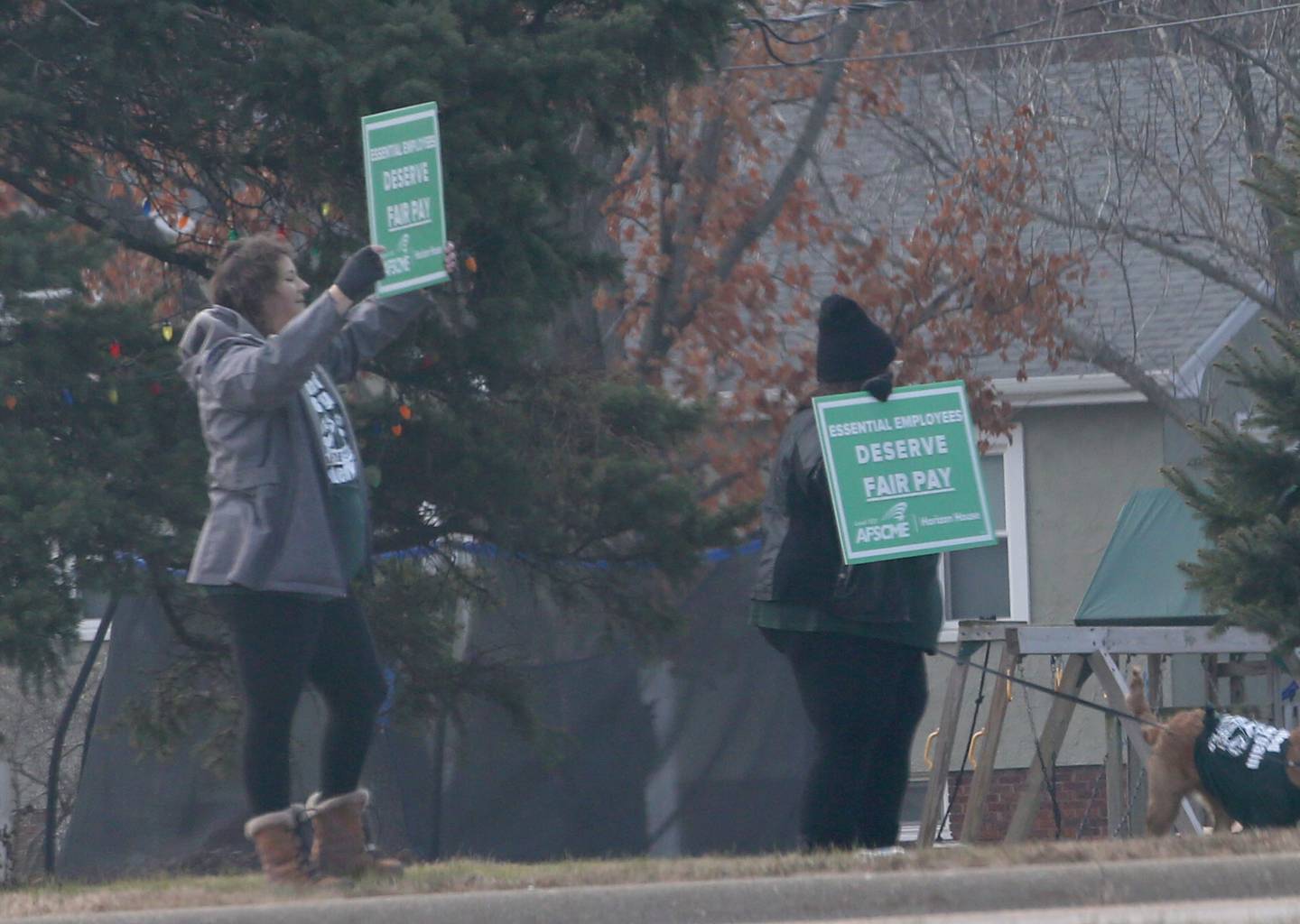 Horizon House employees hold signs reading "deserve better pay" outside of the Horizon House on Thursday, Dec. 8, 2022 in Peru.