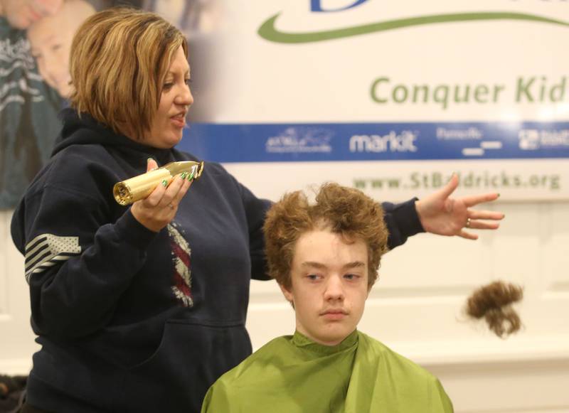 Michelle Brown takes the "first swipe" of hair off her son Matthew during the 18th annual Illinois Valley Emergency Services St. Baldrick's event on Sunday, March 23, 2025 at Senicas Oak Ridge in La Salle.