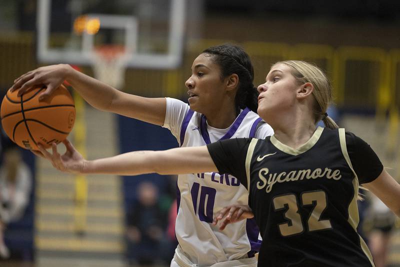 Plano’s Jailyn Brown and Sycamore’s Quinn Carrier reach for a loose ball Monday, Feb. 17, 2025, during a 3A semifinal in Sterling.