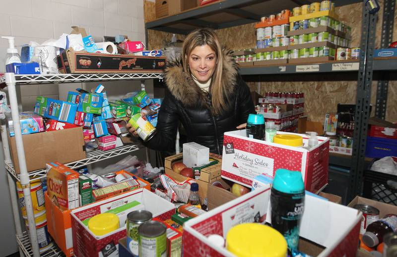 Adriana Garcia, of Chicago, a volunteer, packs boxes with canned goods for patrons at the P.L.A.N. Food Pantry in Round Lake Beach.