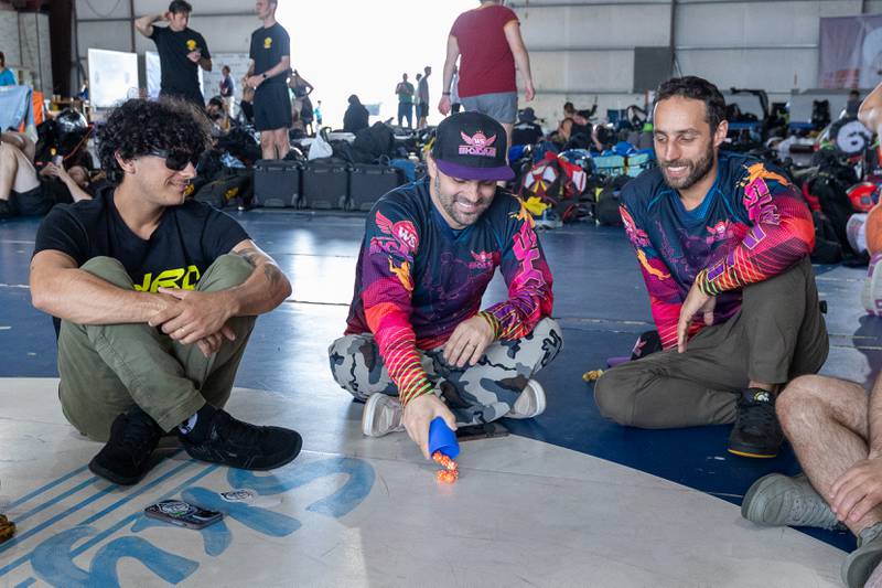 (from left) Felipe Assis, William Starostikon and Joao Roncato play game whilst waiting for weather delay to be lifted on Wednesday, Aug 20, 2025 at Skydive Chicago in Ottawa.