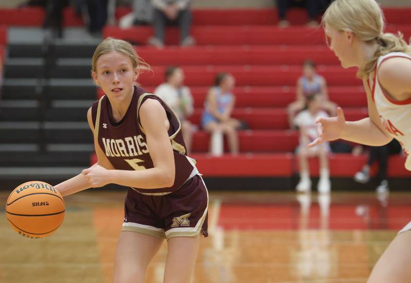 Morris's Ava Petersen looks to pass the ball off around Ottawa's Libby Muffler on Tuesday, Dec. 9, 2025 in Kingman Gymnasium at Ottawa High School.