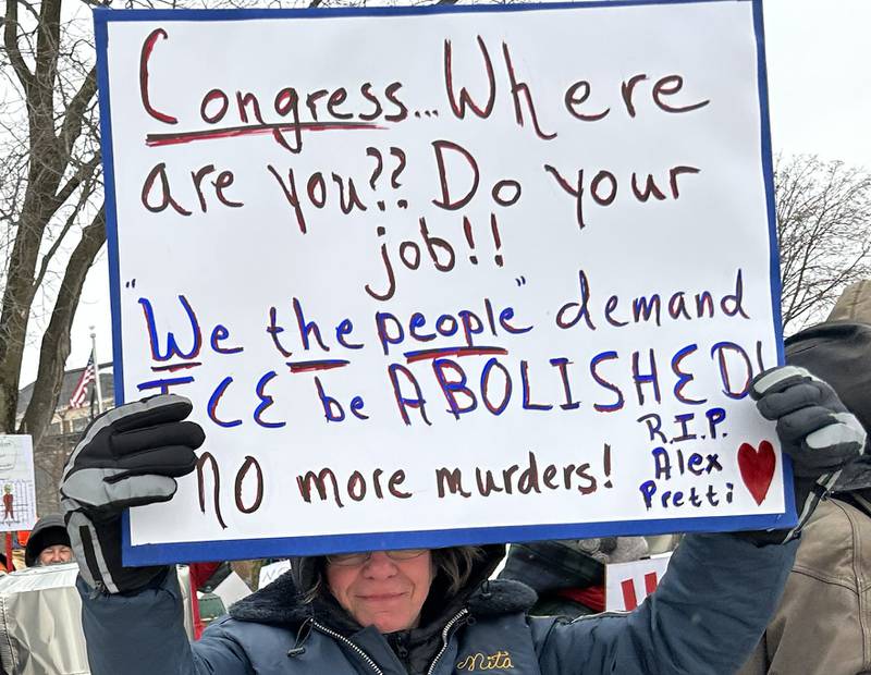 A person holds a sign at the Sunday, Jan. 25, 2026, protest organized by Indivisible of Ogle County in downtown Oregon.