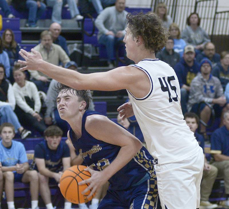 Marquette’s Griffin Dobberstein tries to shoot under the block of  Erie/Prophetstown’s Gus Schultz in the 3rd period Monday at the Serena Huskers Hardwood Tip-Off Tournament.
