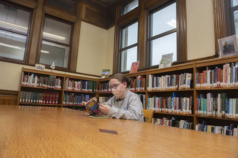 Cecilia Sagel, 17, of Dixon reads Wednesday, April 13, 2022 at the Dixon library. The library announced it will be eliminating fines for overdue items.