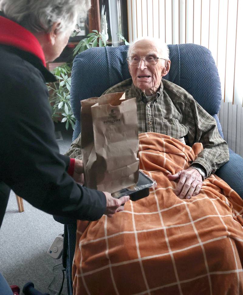 Colette Theurer, a driver with the Voluntary Action Center, delivers a meal to 102-year-old Wilbur Kocher, Thursday, Nov. 17, 2022, at his home in Sycamore. VAC delivers meals to the homebound and elderly along with providing transportation options.