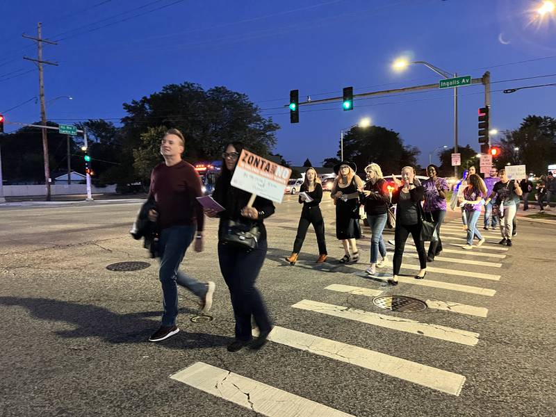 Marchers walk across an intersection on Larkin Avenue for Will County Take Back The Night on Thursday, Oct. 5, 2023, in Joliet.