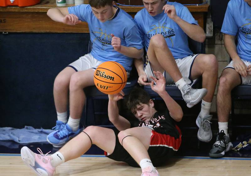 Earlville's Landen Tirevold tries to save the ball from going out of bounce against Marquette on Friday, Jan. 3, 2025 in Bader Gym at Marquette High School.
