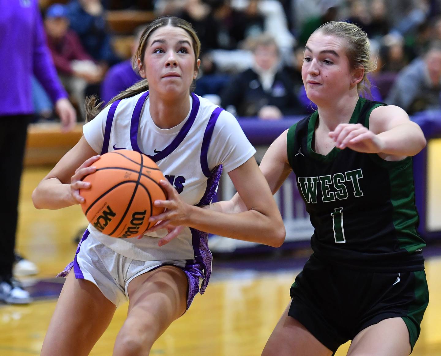Downers Grove North’s Eva Yerkovich goes to the basket as Glenbard West’s Nina Hendricksen (1) defends during a game on January 17, 2026 at Downers Grove North High School in Downers Grove .