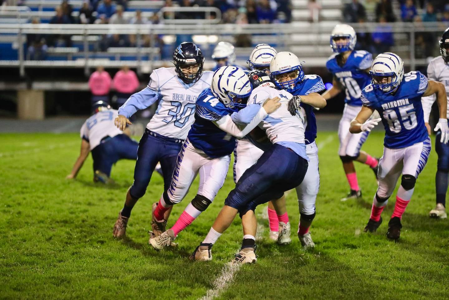 Princeton's Evan Driscoll (14) gets some help bringing down Bureau Valley's Brock Foster Friday night at Bryant Field.