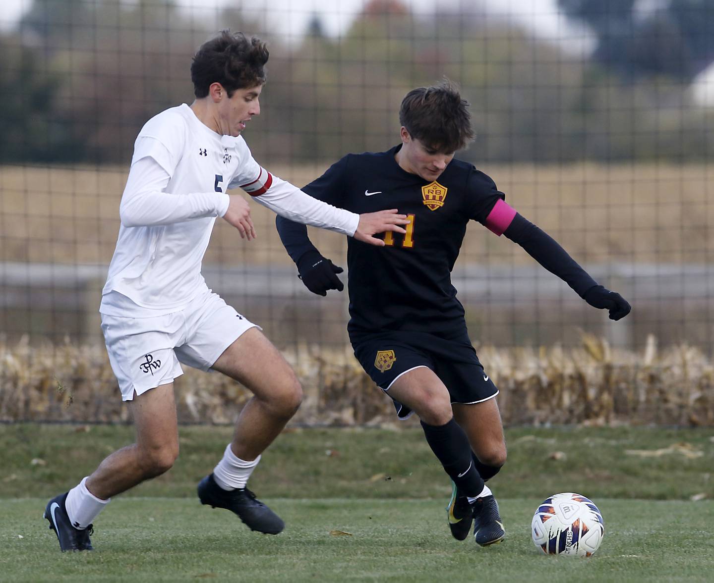 Richmond-Burton's Jack Meyer (right) tries to get position to take a shot on goal as F.W. Parker's F.W. Parker's Heath Albert defends during an IHSA Class 1A Johnsburg Sectional semifinal match on Oct. 28, 2025, at Johnsburg High School.