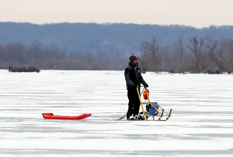 A racing official uses a motorized sled to maneuver around the ice on Senachwine Lake on Thursday Jan. 27, 2022 near Putnam.