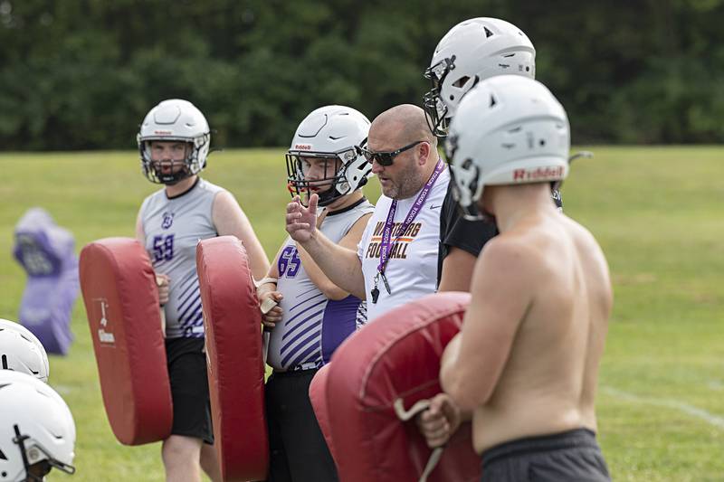 Dixon High School head football coach Jared Shaner runs his team through drills Monday, Aug. 12, 2024, during the first day of football practice.