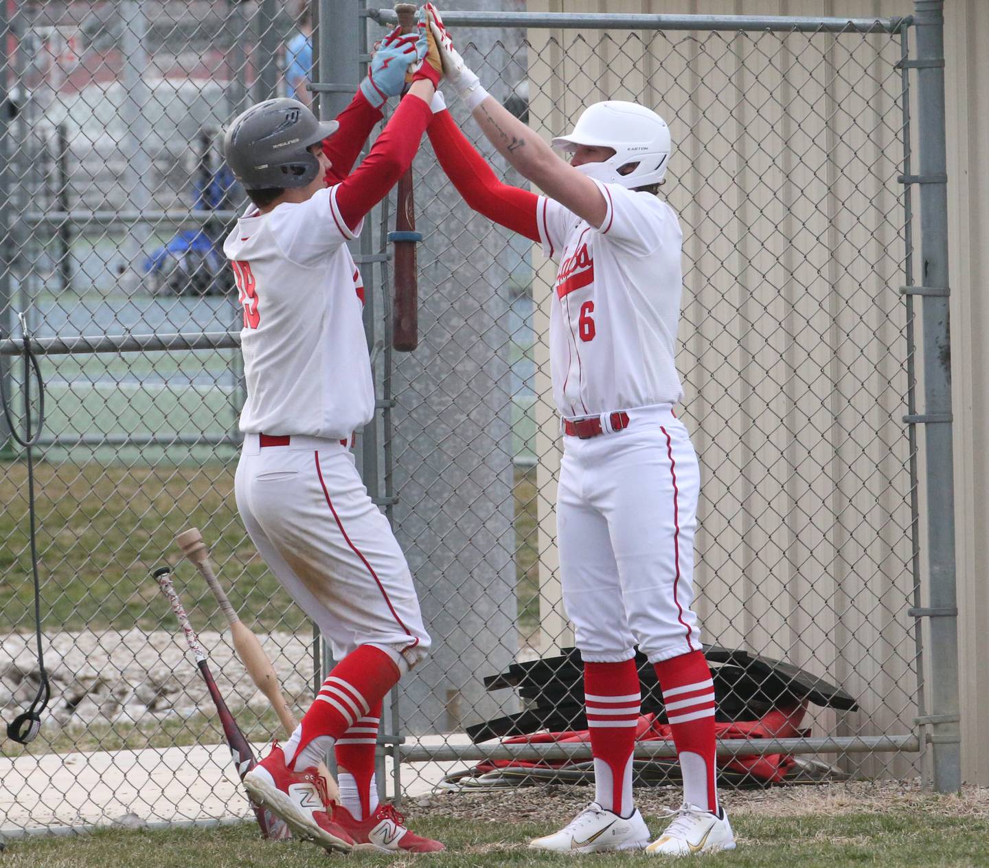 Ottawa's Payton Knoll hi-fives teammate Packston Miller after scoring a run on Tuesday, March 21, 2023 at Ottawa High School.